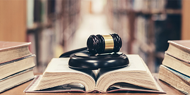 La copie fiable garantit que la copie numérique est identique à l'original papier mais assure la valeur probatoire du document numérique. Marteau de la justice sur livre ouvert symbolisant la valeur probatoire du document.