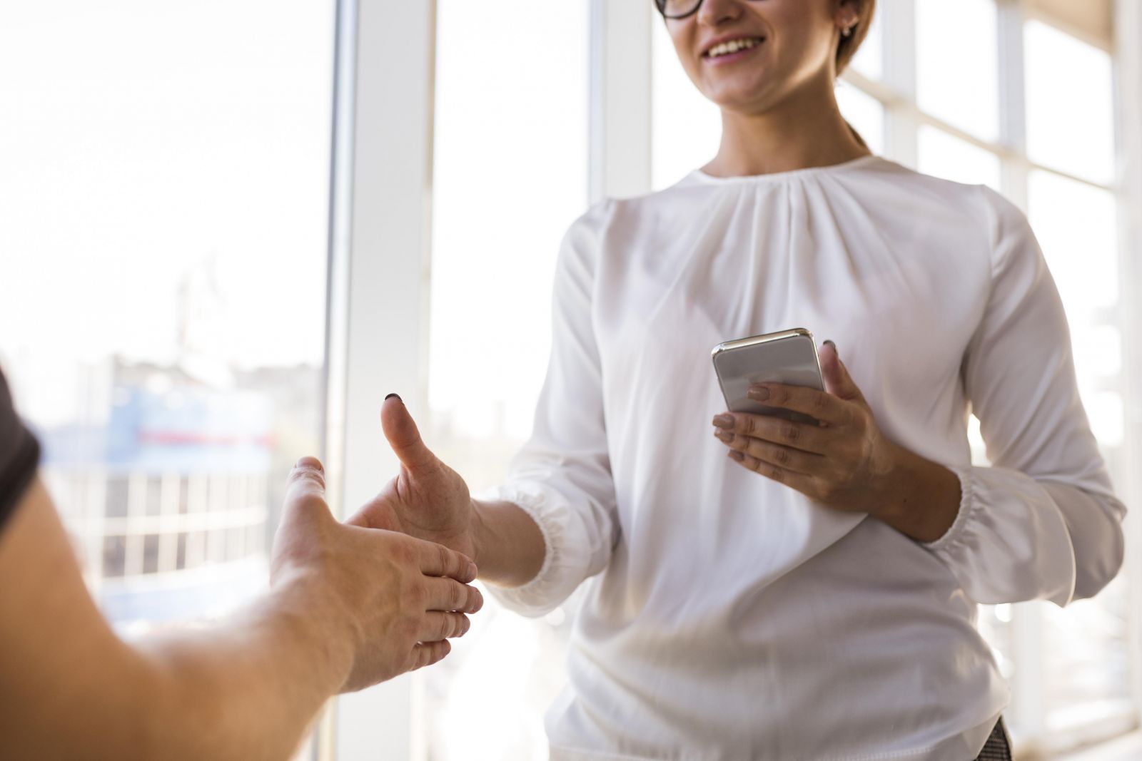 Numen s'engage auprès de ses clients à toujours proposer des solutions innovantes. Image d'une femme serrant la main à un homme. La femme sourit. 